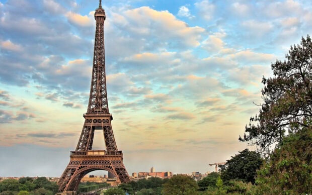 The iconic Eiffel Tower in France standing tall against a partly cloudy sky