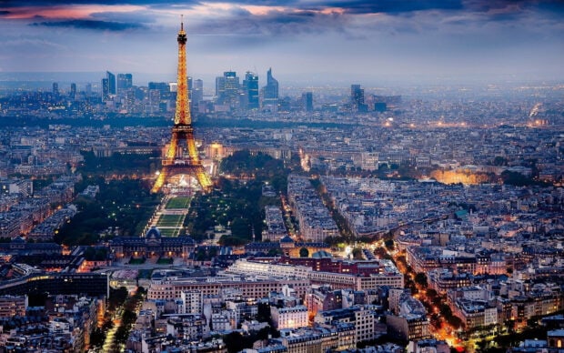 Evening view of France cityscape with Eiffel Tower illuminated during sunset