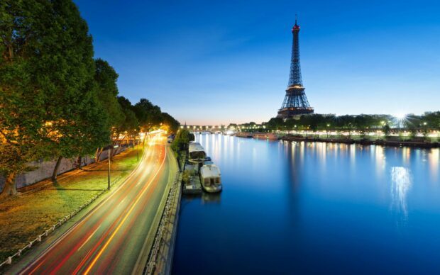 Night view of France river with Eiffel Tower and illuminated trees lining the street