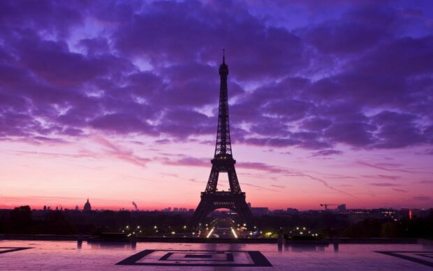 The Eiffel Tower in France stands tall under a vibrant purple sky at sunset