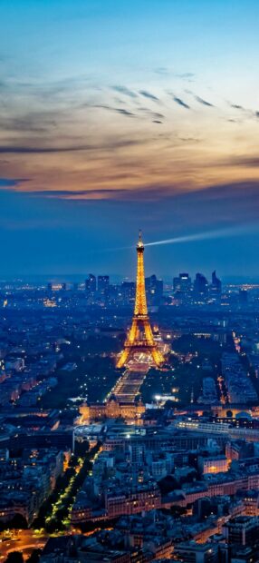 Evening view of the Eiffel Tower in France lit up against a twilight sky