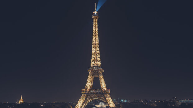 Illuminated Eiffel Tower at night in France with city skyline