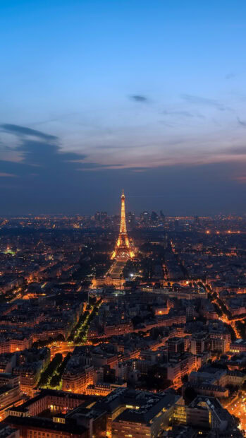 Illuminated Eiffel Tower in France cityscape at dusk with glowing street lights