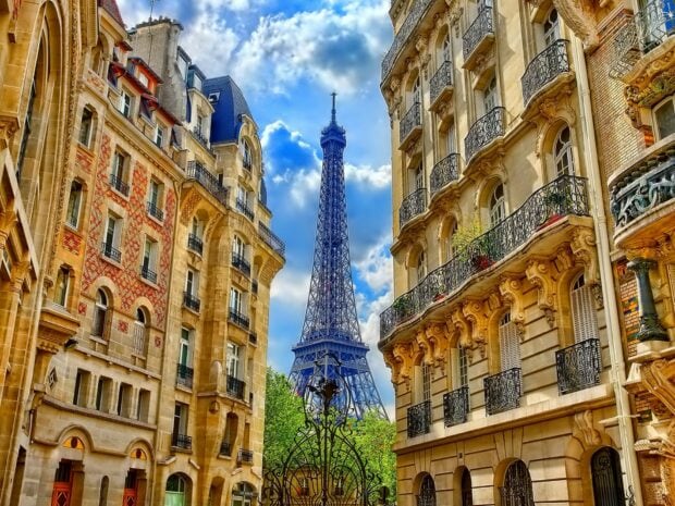 The Eiffel Tower surrounded by classic Parisian buildings in a charming street in France