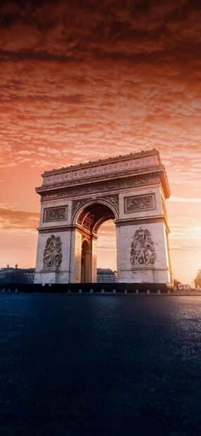 The famous monument of France Arc de Triomphe stands under a vibrant sunset sky