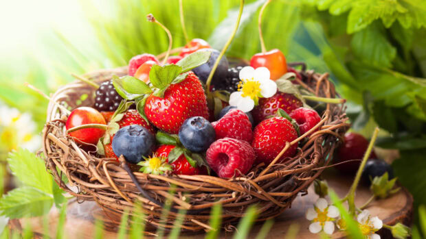 A basket filled with fresh berries including strawberries, raspberries, and blueberries in natural light, 4K Desktop Wallpaper