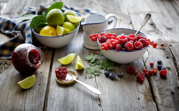 A bowl of fresh berries and lime slices displayed on a wooden surface, HD Desktop Wallpaper