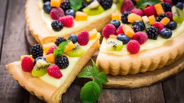 A delicious pie topped with fresh berries and kiwi on a wooden surface, HD Desktop Wallpaper