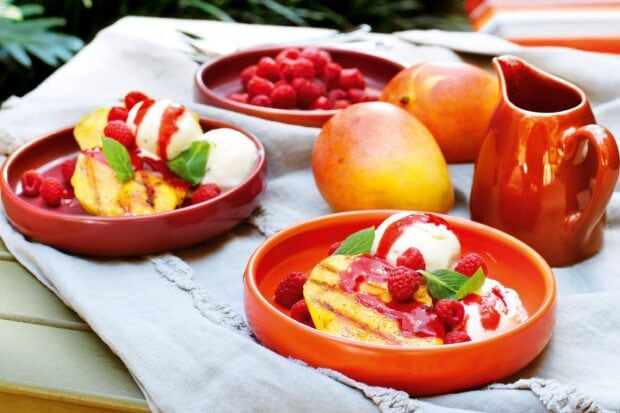 Fresh mango desserts with raspberries and cream on a table for summer treats, 2K Desktop Wallpaper