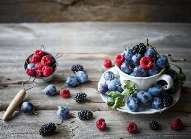 A cup and sieve filled with fresh berries on a wooden table for berries wallpapers, HD Desktop Wallpaper