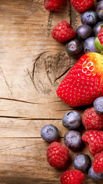 This image features fresh berries including strawberries, raspberries, and blueberries on a wooden table, 4K Phone Wallpaper