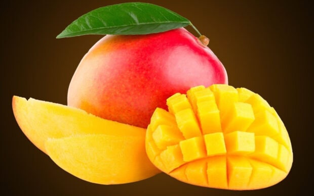 A fresh ripe mango with sliced cubes placed on a brown background, HD Desktop Wallpaper