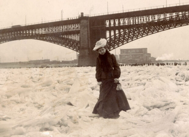 A woman stands on ice near the frozen Mississippi River under a large bridge, HD Desktop Wallpaper