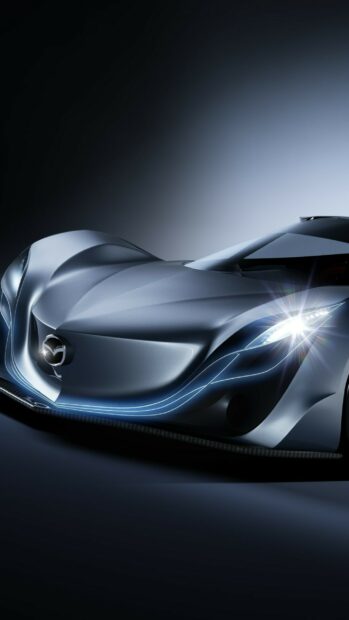 A futuristic Mazda car with sleek curves and bright headlights is shown in this Mazda Wallpapers, 2K Phone Wallpaper