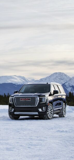 A black GMC vehicle is parked on snow with mountains in the background showcasing classic rugged design, HD Mobile Wallpaper