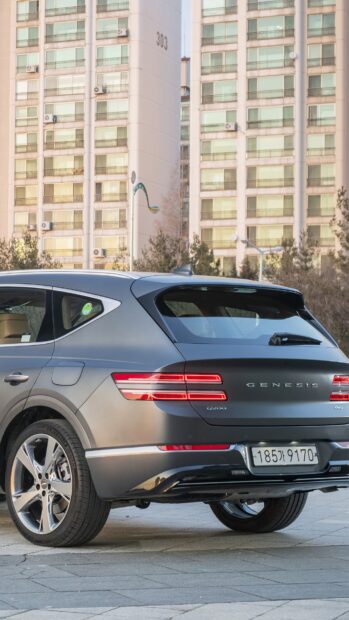 A Genesis car is parked near tall residential buildings at sunset, 4K Mobile Wallpaper