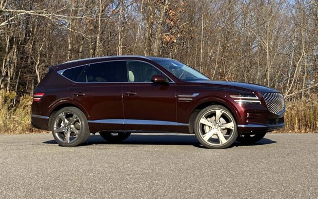 A maroon Genesis SUV is parked on a road with leafless trees behind it, HD Desktop Wallpaper