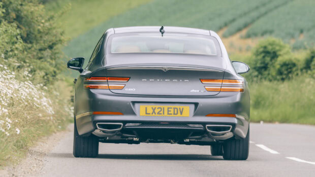 A Genesis Wallpapers luxury car is shown from behind on a country road, 2K Desktop Wallpaper