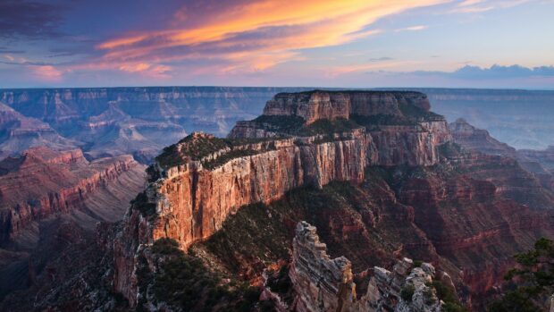 Stunning geology formations of canyon cliffs under a colorful sunset sky