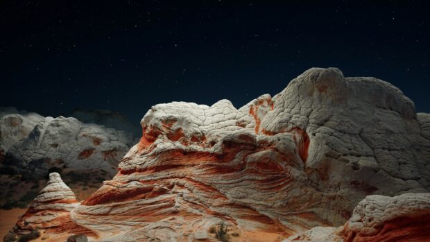 Unique geological formations with layered sedimentary rock under a starry night sky