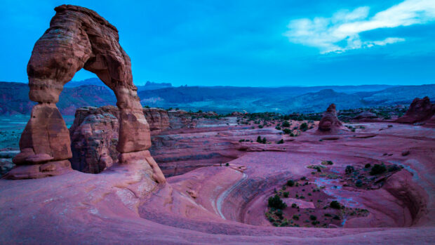 A natural rock formation showcasing unique geology features in a desert landscape under a blue sky