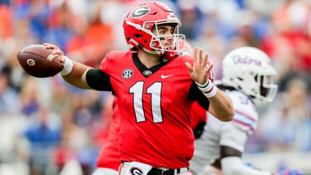 Georgia Bulldogs player wearing red jersey preparing to throw a football during a game