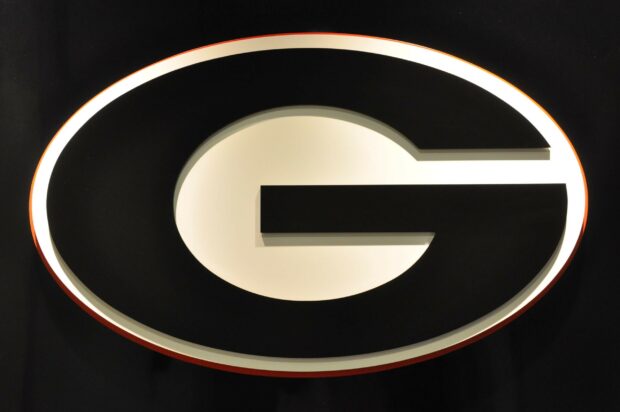 Close up of Georgia Bulldogs logo in black and white on a dark background