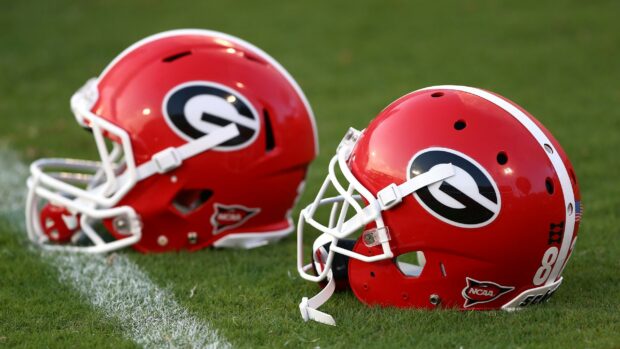 Red Georgia Bulldogs helmets with team logos placed on green grass field