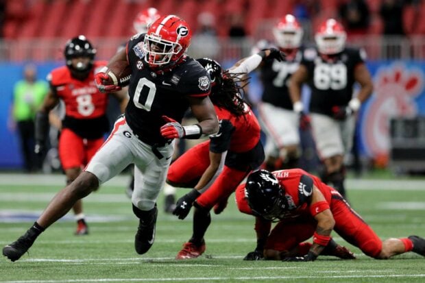 Georgia Bulldogs football player running with the ball during a game on the field