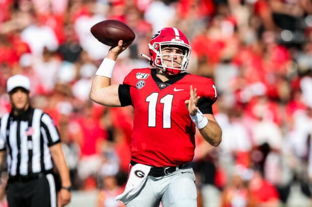 Georgia Bulldogs player wearing a red jersey preparing to throw a football on the field