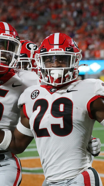 Georgia Bulldogs football player wearing number 29 celebrating on field in white uniform