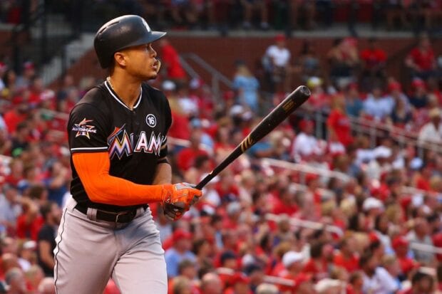 Giancarlo Stanton preparing to bat during a baseball game with a crowded stadium background