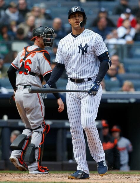 Giancarlo Stanton standing at home plate during a baseball game wearing a New York Yankees uniform