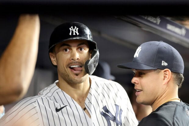 Giancarlo Stanton celebrating with teammates in a New York Yankees uniform