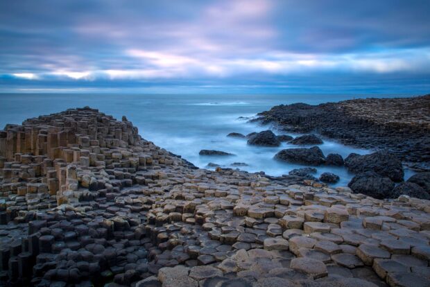 The iconic Giants Causeway rocks stretch along the coast in Northern Ireland under a cloudy sky, 2K Desktop Wallpaper