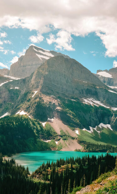 A turquoise lake surrounded by pine trees and towering mountains at Glacier National Park, HD Mobile Wallpaper