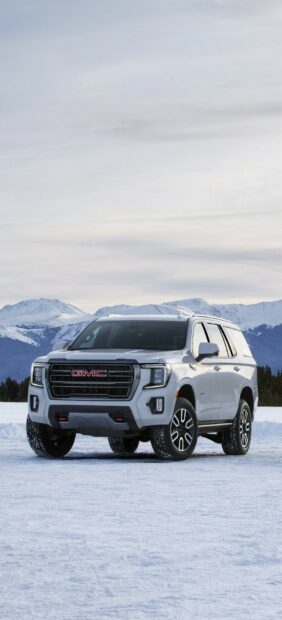 A GMC SUV parked on snow with mountains in the background, 2K Phone Wallpaper
