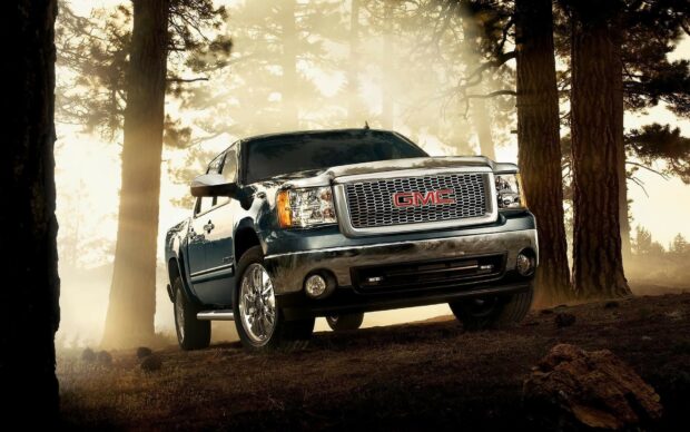 A GMC truck parked in a misty forest with sunlight filtering through the trees, HD Desktop Wallpaper