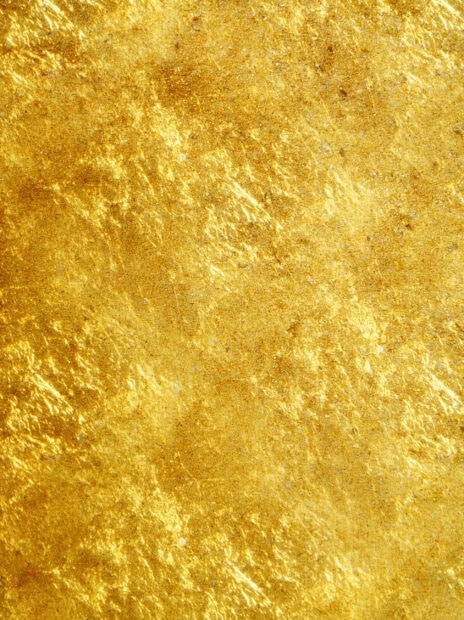 Close up view of detailed gold foil texture with shiny reflective patterns