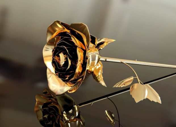 A shiny gold foil rose with detailed petals and leaves in close up view