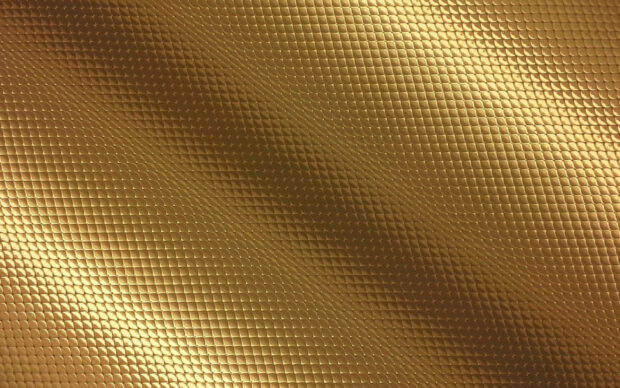 Close up of gold foil texture with geometric pattern and shiny surface
