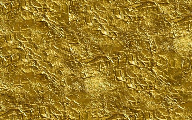Crumpled gold foil texture creating a shiny and luxurious surface