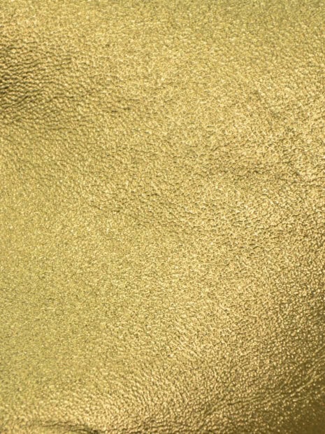 Close up of textured gold foil material showing fine details and shine