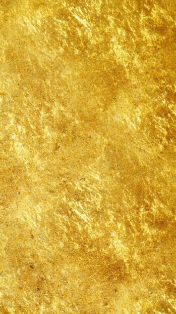 Shiny gold foil texture with detailed patterns on a vertical surface