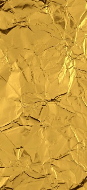 Crinkled gold foil texture with shiny and reflective surfaces