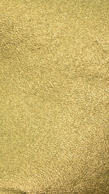 Close up of gold foil texture showing detailed patterns and shiny surface