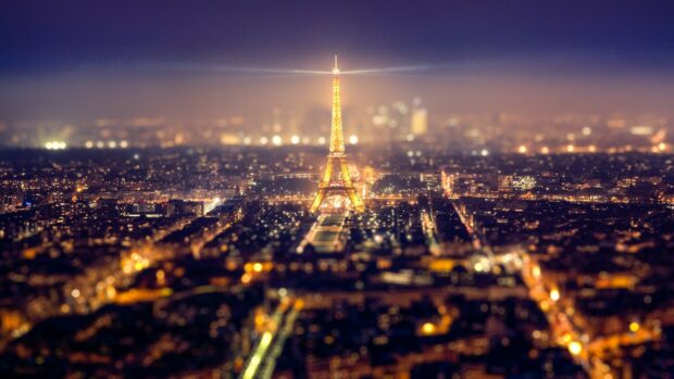 Golden lights illuminate the Eiffel Tower in the night cityscape