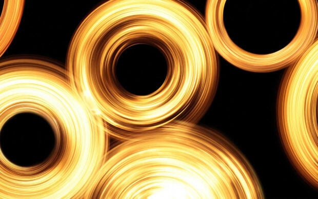 Circular golden light rings swirl against a dark background creating a glowing abstract pattern