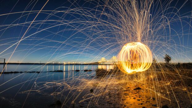 Golden lights creating dynamic patterns over the riverbank at night