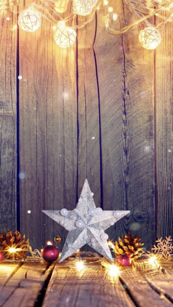 Silver star decoration with gold lights on wooden surface and festive ornaments